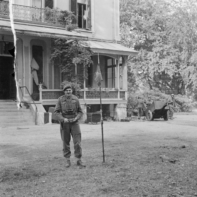 Major-General Roy Urquhart DSO and Bar (leader of the 1st British Airborne Division during the Arnhem Operation) plants the Airborne flag outside his headquarters (Hotel Hartenstein), the last British stronghold in the Arnhem area before the evacuation